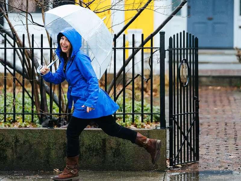 Sarah B. Miller skips in rain with umbrella